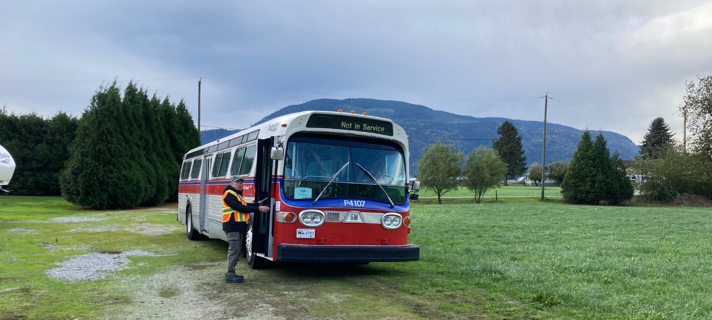 A bus parked on a gravel road

Description automatically generated