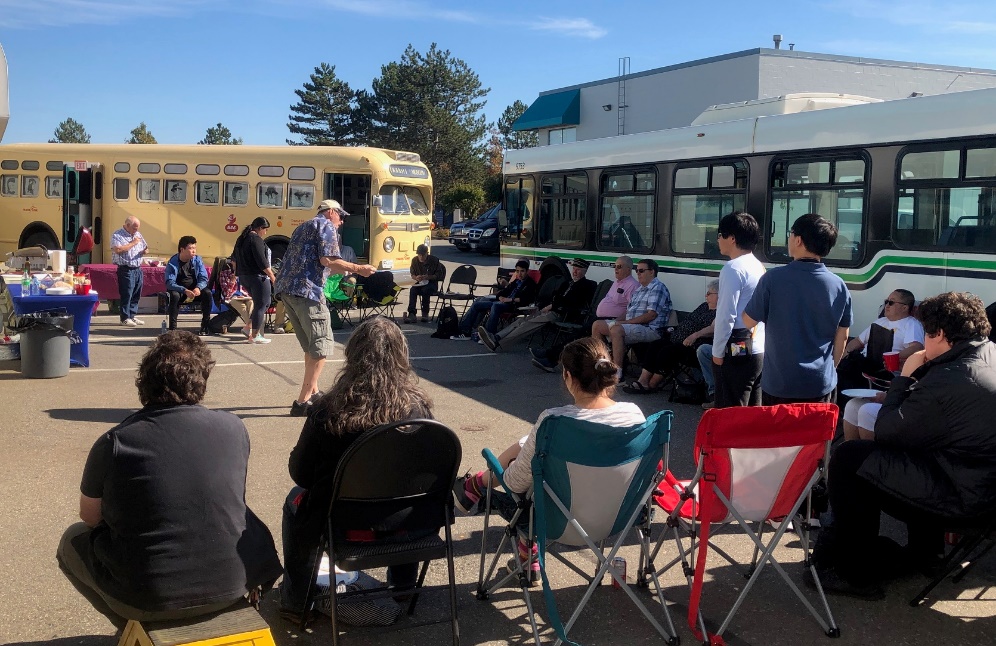 A group of people sitting in chairs outside

Description automatically generated