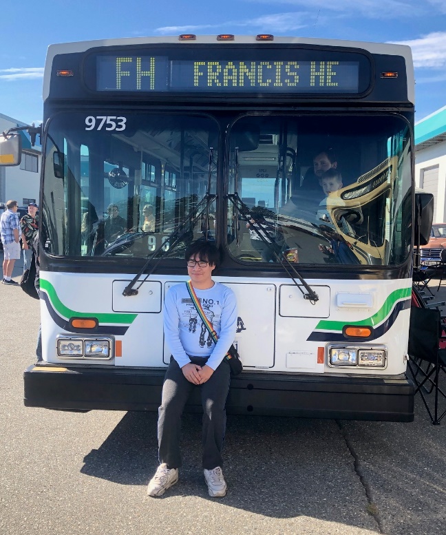A person sitting in front of a bus

Description automatically generated