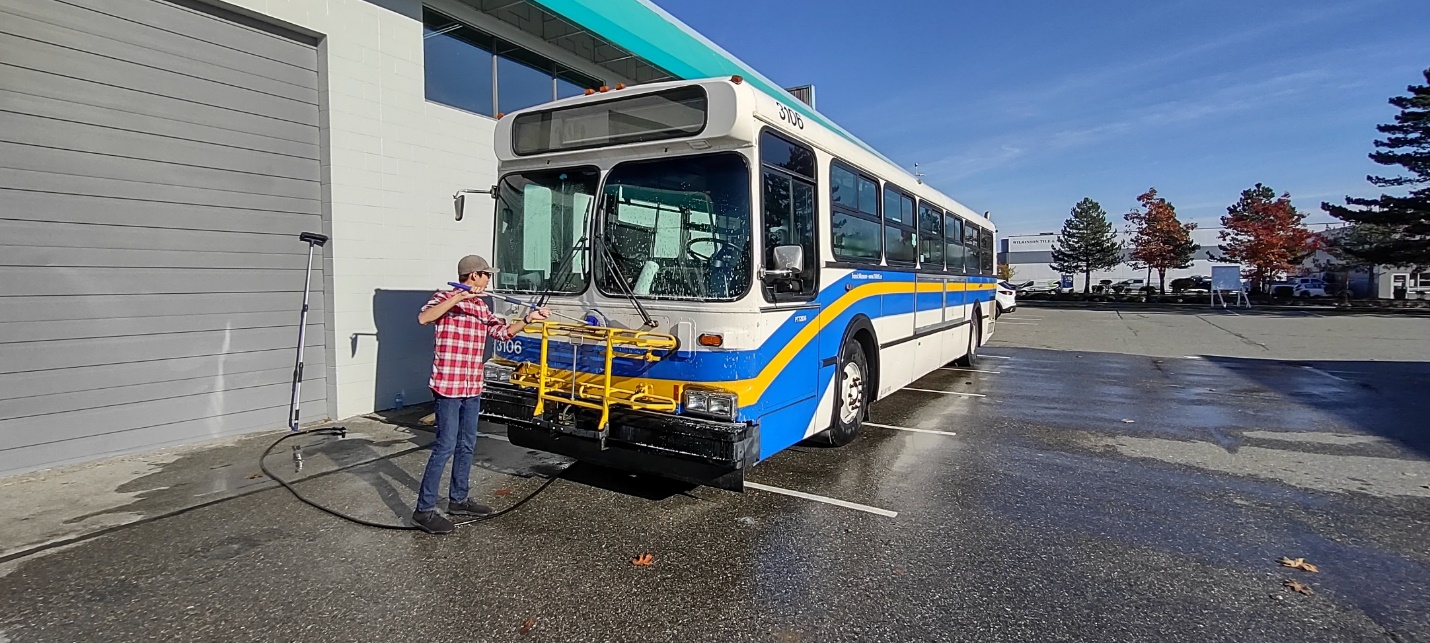 A person standing next to a bus

Description automatically generated